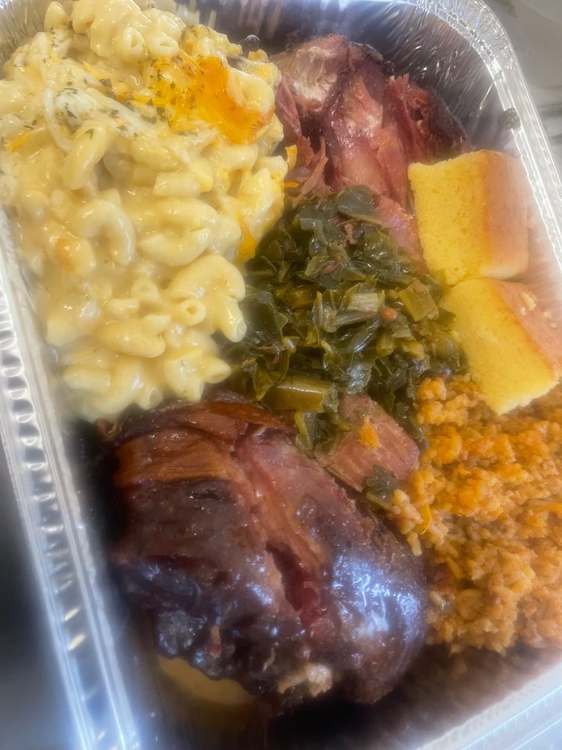 Southern comfort food in a foil pan: macaroni and cheese, collard greens, ham, cornbread, and rice.